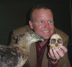 Professor Lee Berger with a stuffed African hawk eagle and a copy of the Taung child skull 